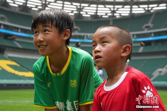 圖為北京國(guó)安小球員陳小北和7歲的俄金仁增在一起觀看場(chǎng)內(nèi)播放的紀(jì)錄片。<a target='_blank' href='/' _fcksavedurl='/'><p  align=