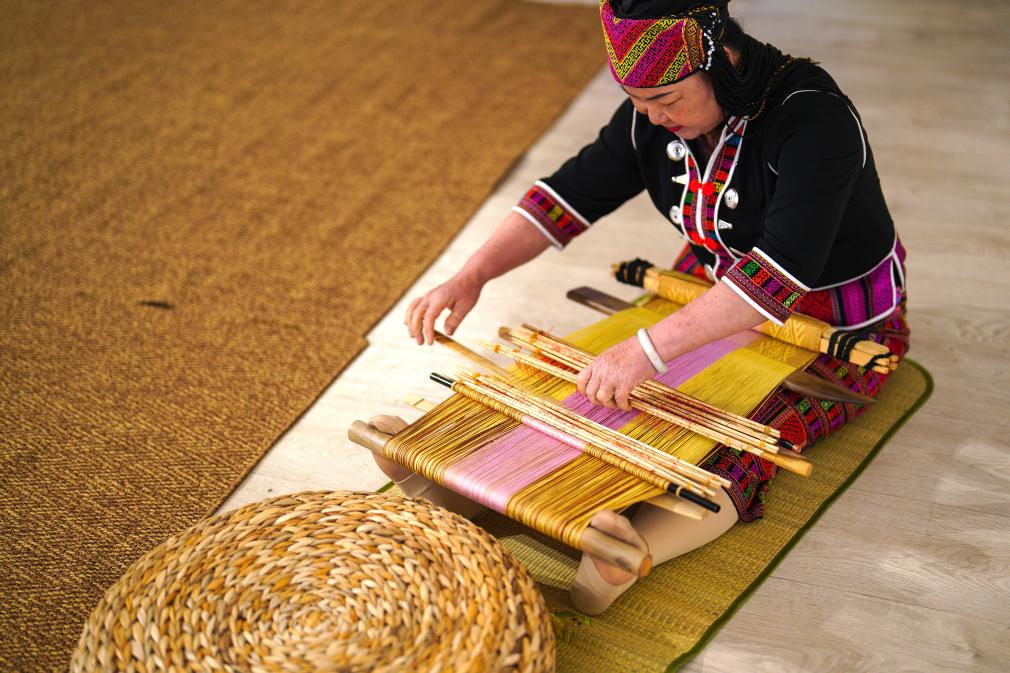 4月17日，黎族傳統(tǒng)紡染織繡技藝國家級代表性傳承人劉香蘭在2023年意大利米蘭設計周上展示黎錦織造技藝。新華社發(fā)