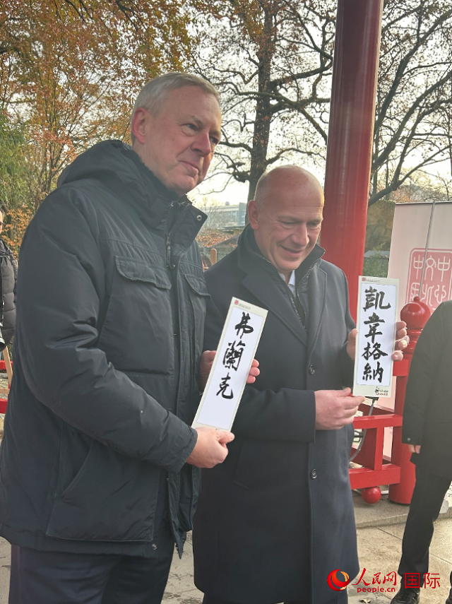 柏林市長韋格納（右）、動(dòng)物園監(jiān)事會(huì)主席布魯克曼（左）手持中國文化中心工作人員現(xiàn)場手書的中文名字。人民網(wǎng)記者 徐馨攝