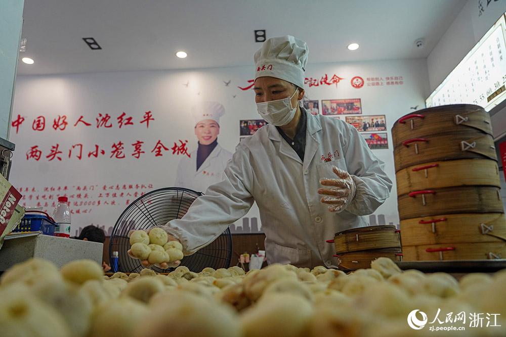 3月31日，在浙江省嵊州市甘霖鎮(zhèn)，嵊州小吃從業(yè)者沈紅平把蒸熟的小籠包晾涼，打包冷藏售賣。人民網(wǎng) 章勇濤攝