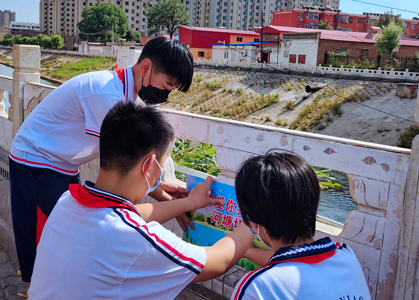 徐水小學(xué)學(xué)雷鋒志愿者在瀑河河邊張貼防溺水警示標(biāo)語。 徐水區(qū)委宣傳部供圖