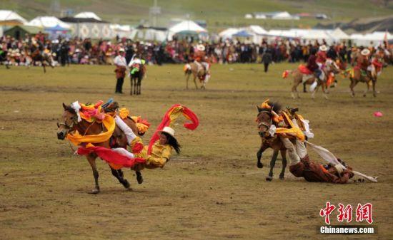 8月4日，四川理塘“八一”賽馬場上演一場精彩的馬術競技比賽，引來上萬民眾和游客觀賽。圖為牧民騎手進行五彩凌空競技。 中新社記者 劉忠俊 攝