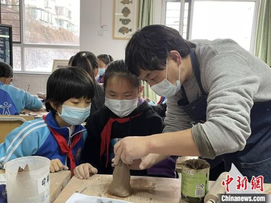 圖為西寧市勞動路小學教師賈煜與學生一起制作陶藝?！≈苋鸪阶?攝