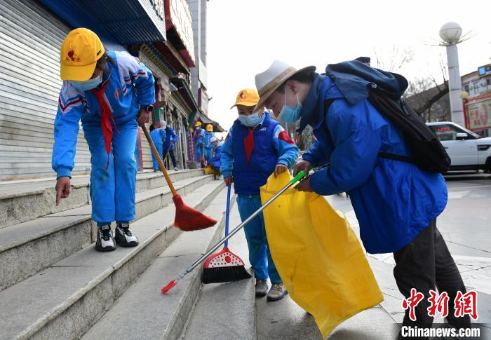 圖為拉薩市小學(xué)生打掃街道?！∝暩聛?lái)松 攝