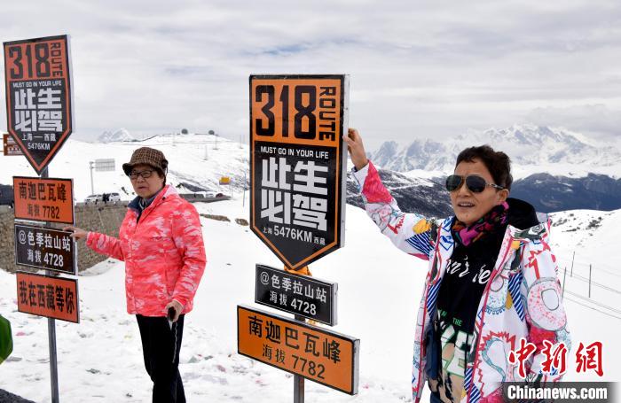 圖為5月14日，西藏林芝色季拉山觀景臺(tái)，游客與南迦巴瓦峰合影?！±盍?攝