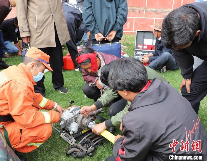 圖為森林消防員為護林員講解滅火裝備的使用方法?！〔际猩窒乐ш?供圖