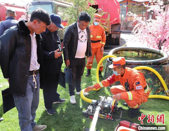 圖為森林消防員為護林員講解滅火裝備的使用方法?！〔际猩窒乐ш?供圖