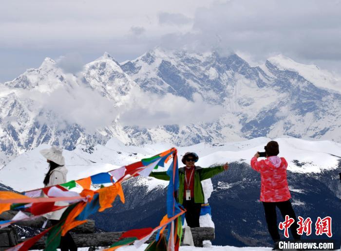 圖為5月14日，西藏林芝色季拉山觀景臺，游客與南迦巴瓦峰合影。　李林 攝