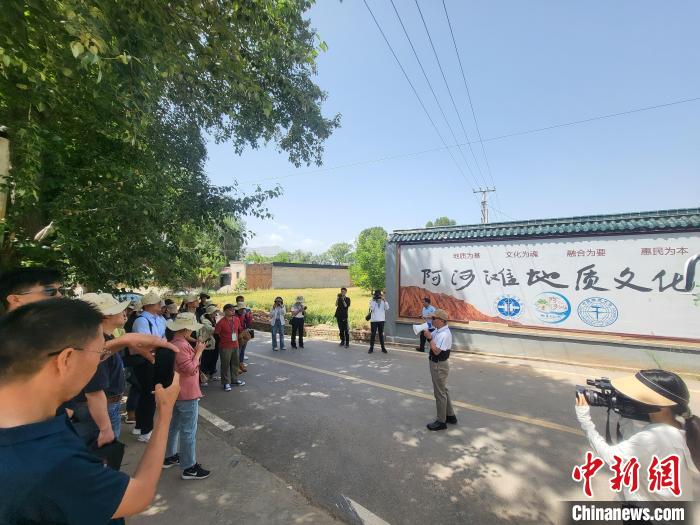 圖為中國地質(zhì)大學(xué)(北京)教授張緒教介紹村落情況。　胡友軍 攝