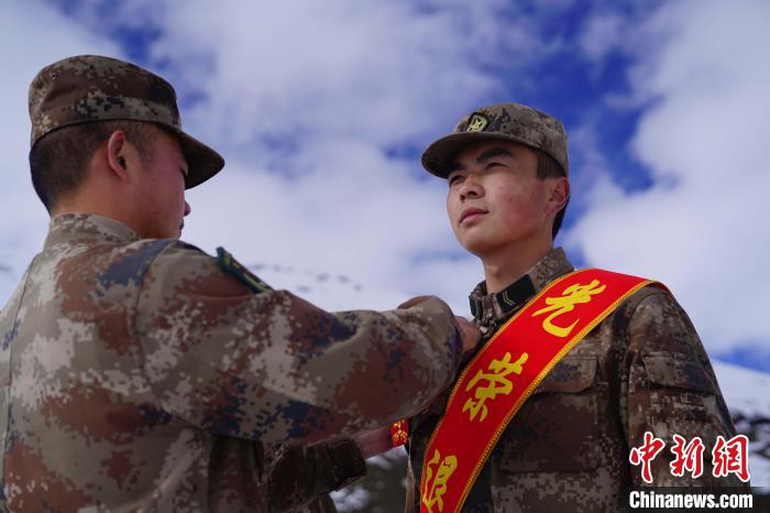 排長王朝偉(圖左)給退伍老兵佩戴大紅花?！∥鞑厣侥宪姺謪^(qū)某團(tuán)供圖