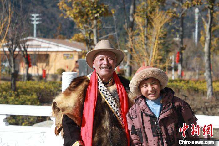 圖為林芝市巴宜區(qū)布久鄉(xiāng)仲果村村民桑杰與孫子一起參加藏歷新年活動?！埩?攝