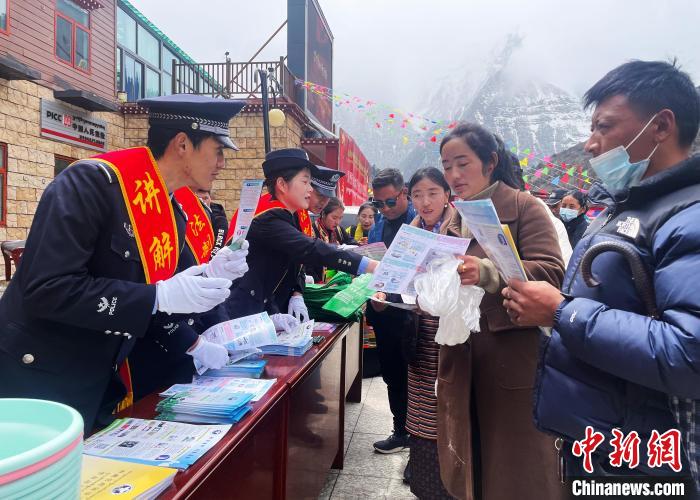 圖為山南玉麥邊境派出所民警為轄區(qū)群眾發(fā)放法律知識宣傳單?！＄婗?　攝